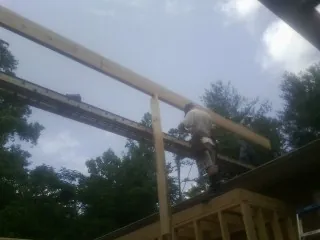 Carpenter setting a ridge beam over a new addition frame — Ice Dam Removal by Roofing Brothers in Stowell