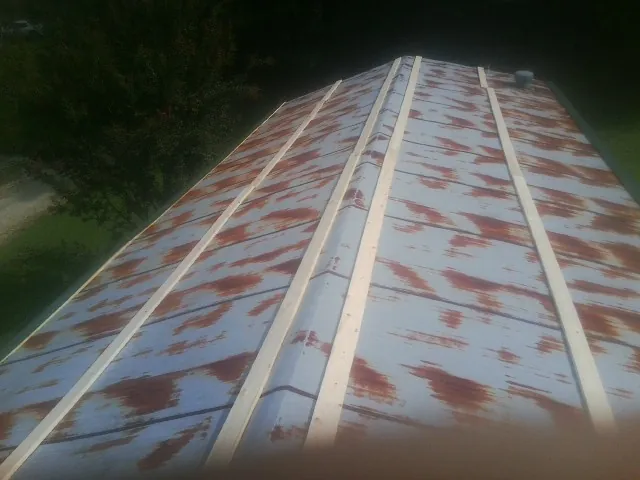 Rusted metal roof panels with new wood purlins before replacement — Storm Damage Roof Repair in Stowell by Roofing Brothers